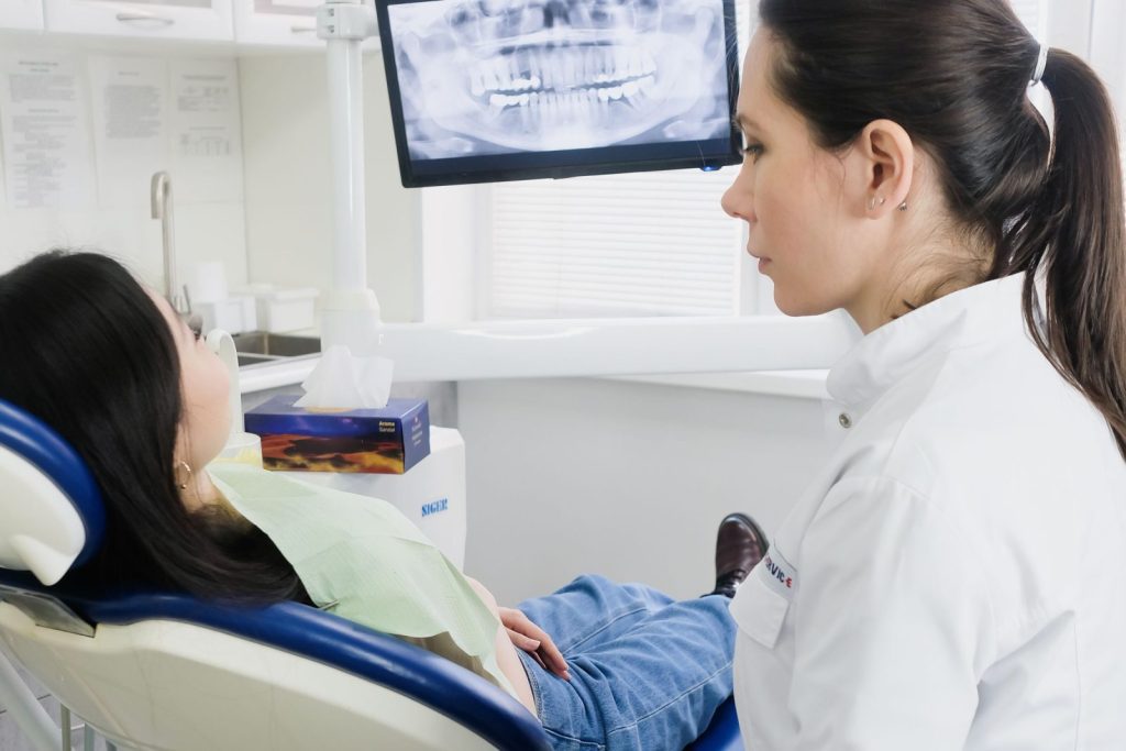 Dentist reviewing a dental X-ray before implant treatment