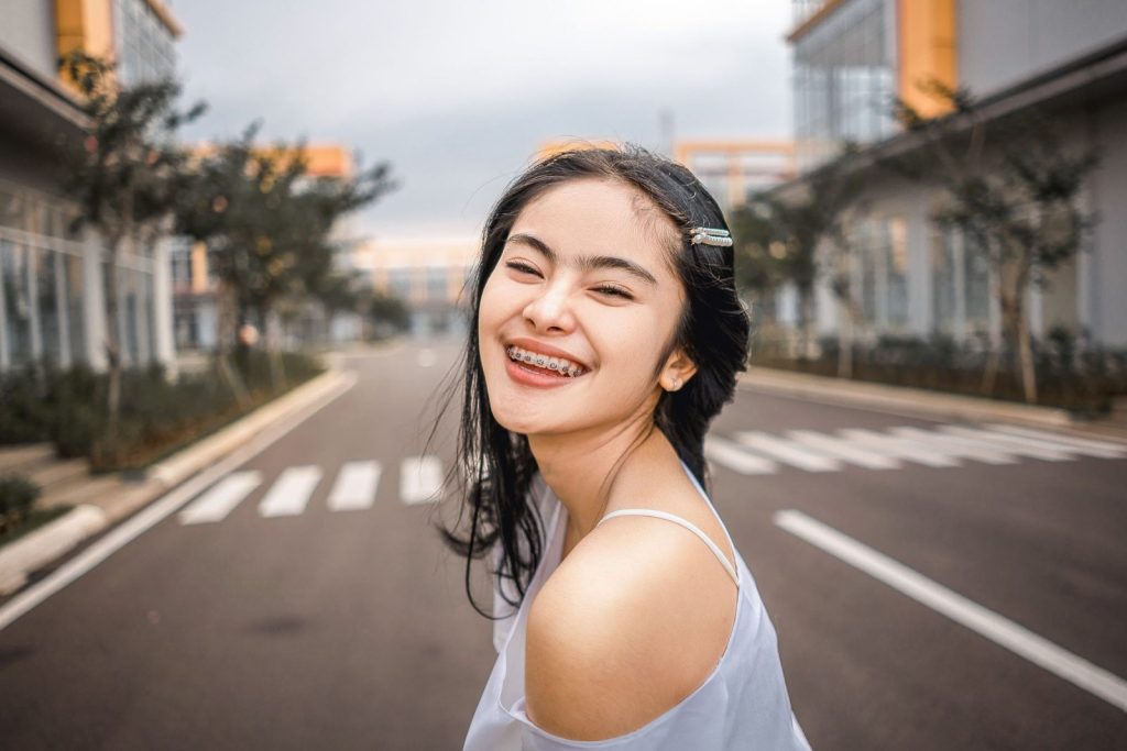 Smiling young woman with braces showing the benefits of orthodontics