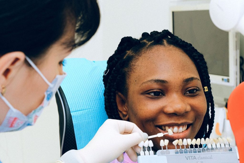 Dentist matching composite veneer shade for a smiling patient
